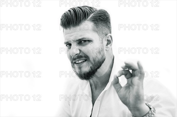 Adult stylish bearded man shows OK sign. Advertising of success