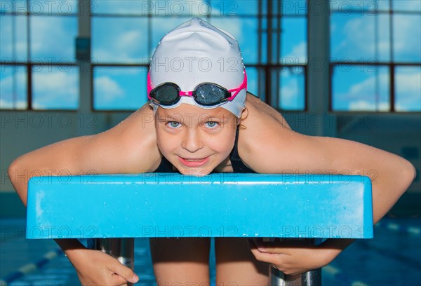 Charming little athlete swims in the pool