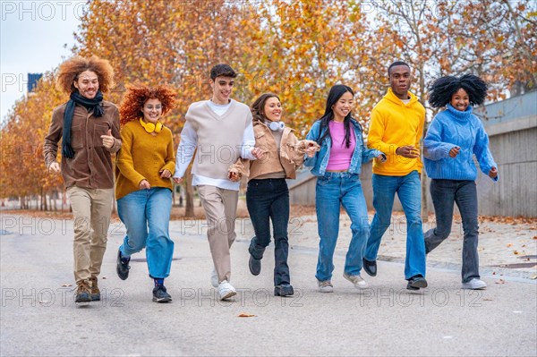 Wide view of multi-ethnic playful friends running along a street