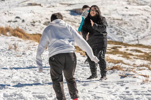 Latin brunette girl playing in the snow at the ski resort in granada