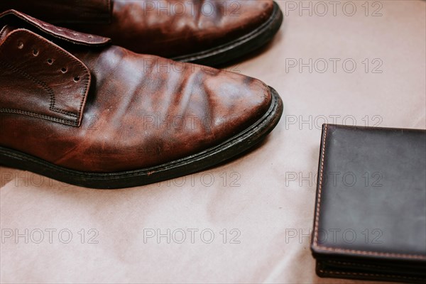 Brown men's shoes made of genuine leather and a brown leather wallet with money