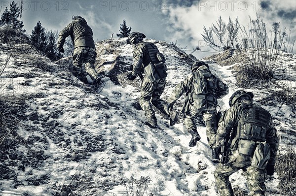 Group of special forces climbs into the mountains in order to take a favorable position to protect the target.