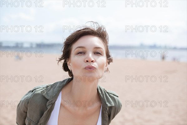 Portrait of a woman sending a kiss to the camera. Windy weather. Happiness