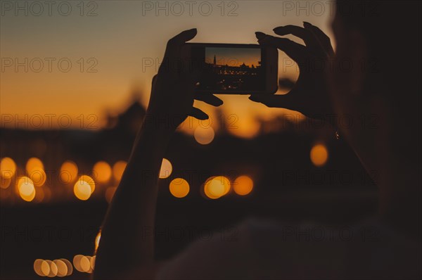 Hands of a girl holding a phone. She takes pictures of Santa Maria Del Fiore. The concept of tourism