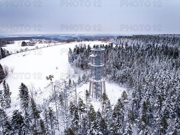 View from above of an observation tower surrounded by snow-covered forest
