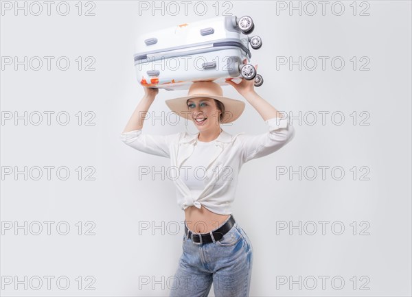 Beautiful girl carries a suitcase on her head on a white background. Tourism concept.