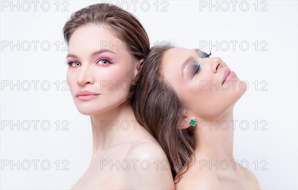 Portrait of two beautiful girls with defiant make-up on a white background. Female friendship concept. High quality