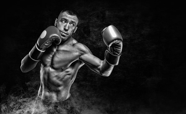 Professional boxer practicing blows in the smoke. Sports betting concept.
