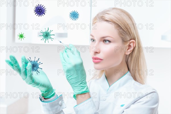 Portrait of a blonde girl in a medical gown with a syringe in her hands. Covid vaccine concept. Epidemic