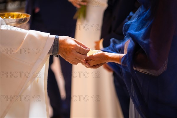 Priest at a wedding at the ceremony gives bread to the bride and groom at the wedding