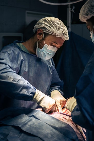 A team of doctors performing spine surgery on a patient with scoliosis inside the operating room