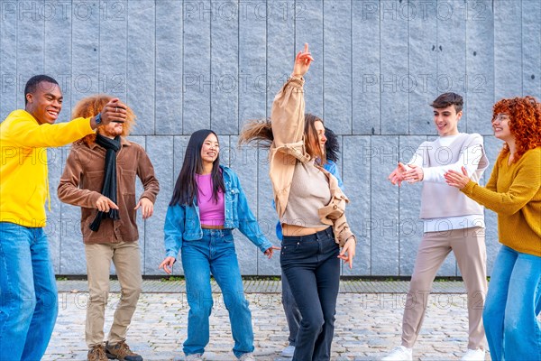 Woman dancing raising arms in the middle of multi-ethnic friends in the street