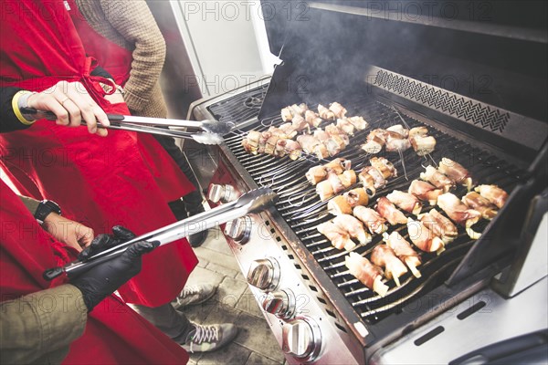 A gas barbecue with various dishes and vegetables on the grill