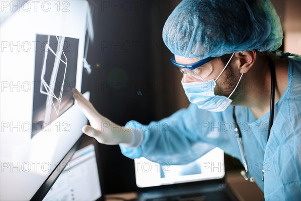 Surgeon examines fluorography images on a monitor in an operating room of a medical office