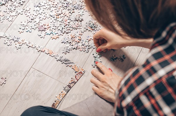 Teenager plays puzzles. The concept of board educational games. Stay at home.