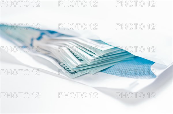 Pack of hundred-dollar bills lies in an envelope. The concept of bribery and corruption.