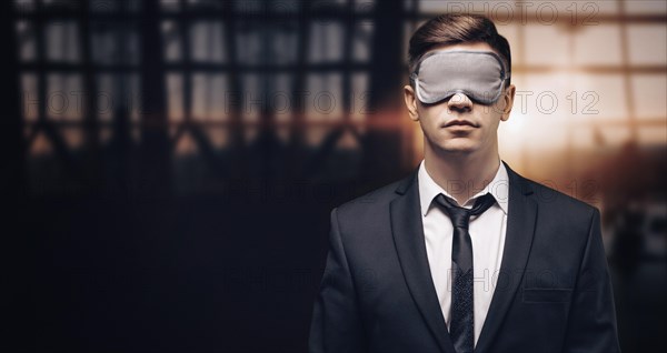 Portrait of a man in a mask for sleeping. He is standing in the airport terminal. The concept of travel