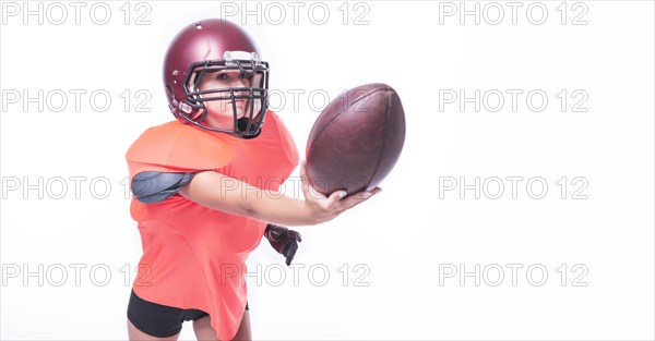 Woman in the uniform of an American football team player throws the ball. Sports concept.