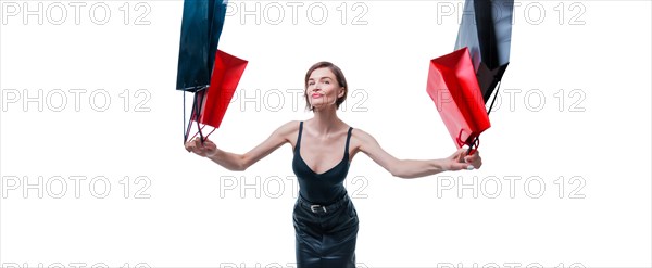 Cheerful positive girl jumps up with happiness and waving shopping bags. The concept of holiday gifts