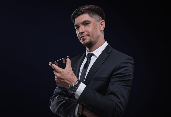 Portrait of a stylish man in a suit with a cigar. Business concept.