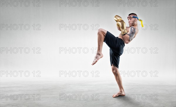 Portrait of a Thai boxer. He hits with his knee. Competitions and tournaments concept.
