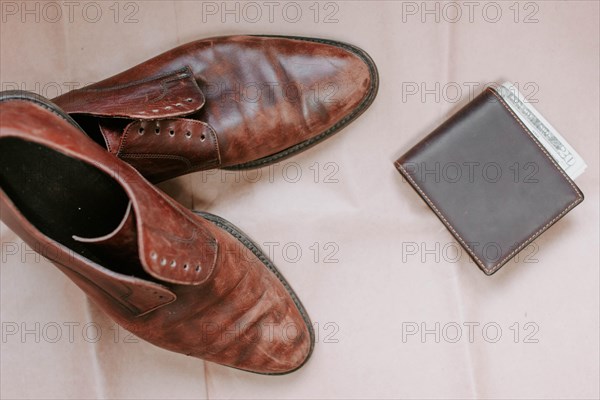 Brown men's shoes made of genuine leather and a brown leather wallet with money