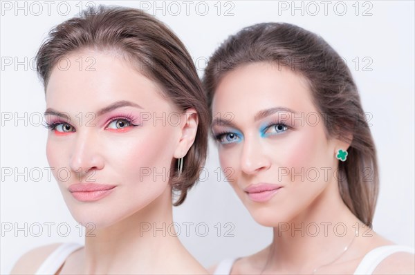 Portrait of two beautiful girls with defiant make-up on a white background. Female friendship concept. High quality