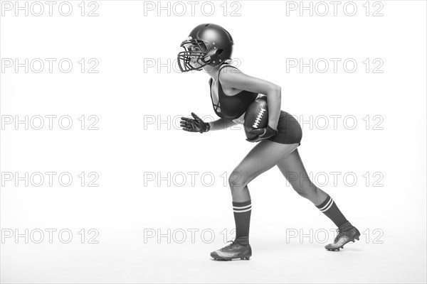 Black and white images of a sports girl in the uniform of an American football team player. Sports concept. White background.