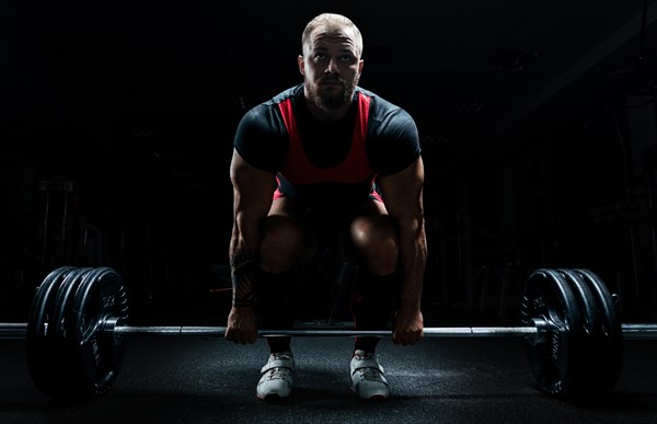 Huge man is preparing to perform an exercise called deadlift.