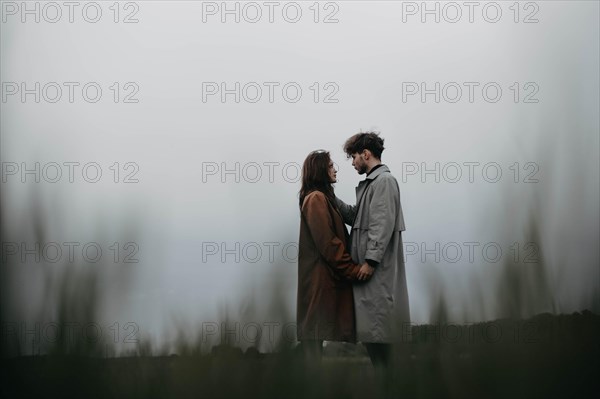 Couple in love in a foggy field. Relationship crisis and dramatic love concept