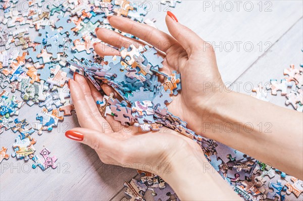 Woman holds a pile of puzzles in her hands. The concept of board educational games. Stay at home.