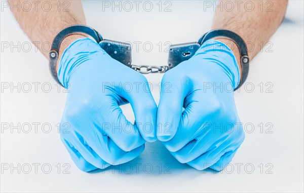 Hands of a doctor in handcuffs. The concept of corruption in medicine.