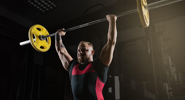 Weightlifter does an exercise with a barbell. Barbell above the head