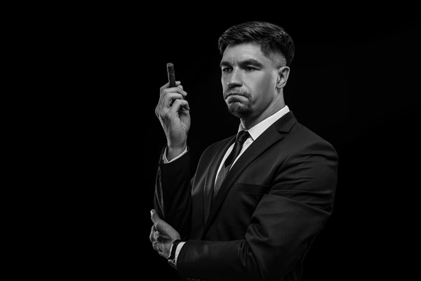 Portrait of a stylish man in a suit with a cigar. Business concept.