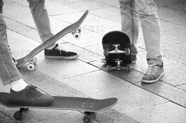 Group of skateboarders are standing near their boards and are preparing to begin training