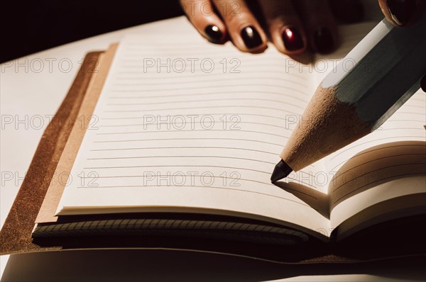 Large pencil is standing on a sheet of a notebook. Concept of business interviewing.