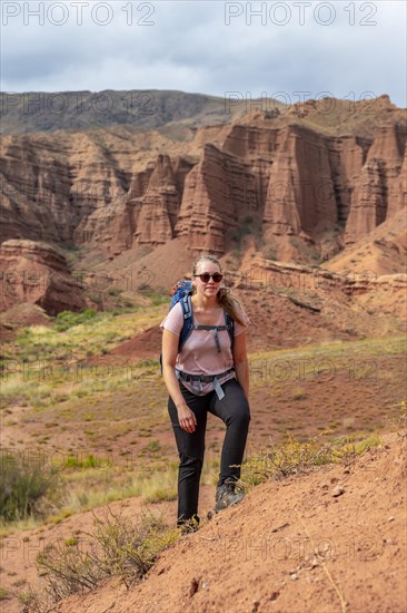 Mountaineer in eroded mountain landscape with sandstone rocks