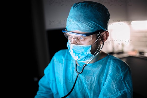 Doctor male surgeon in uniform working with a stethoscope in a medical office