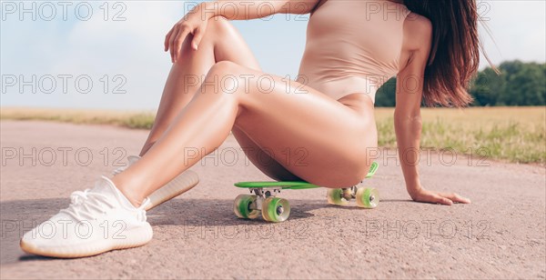 No name portrait of a sexy woman with a skateboard. Recreation and entertainment concept. Sport.