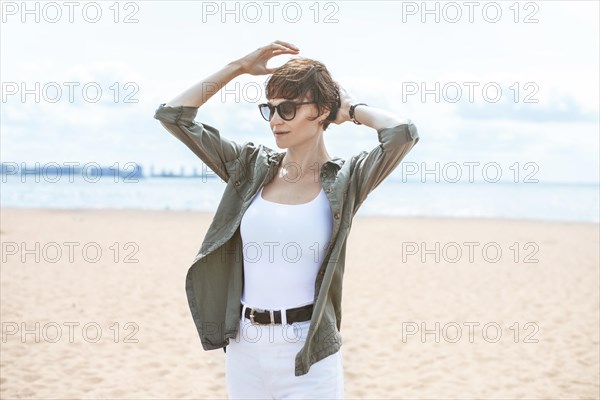 Image of a beautiful woman on the beach of the Gulf of Finland in St. Petersburg. Windy weather. Happiness