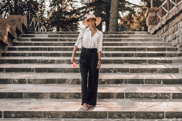 Portrait of a charming girl climbing the stairs to Piazzale Michelangelo in Florence. The concept of tourism