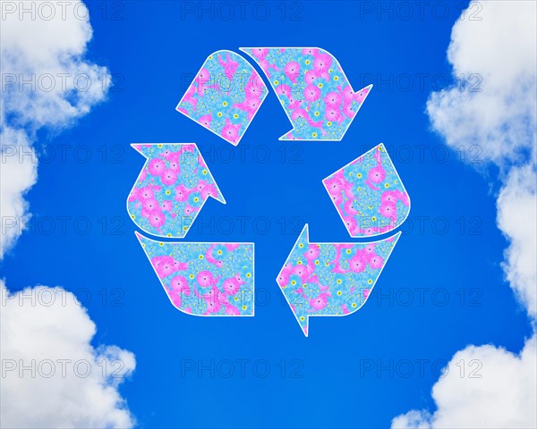 The universal recycling symbol. It is an internationally recognized symbol for recycling. Against blue sky