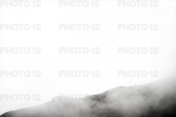 Mountaineer on a mountain ridge in the fog
