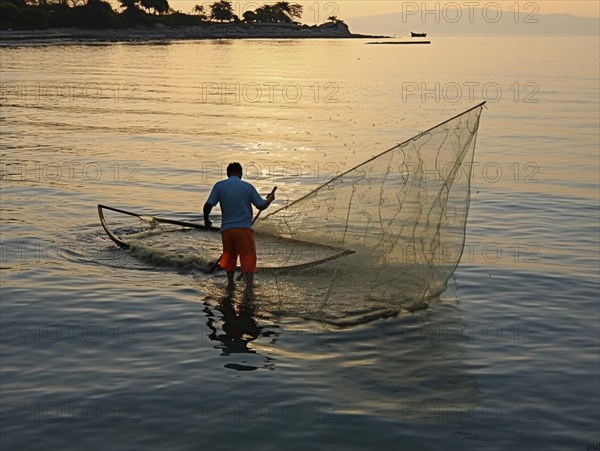 A solitary fisherman on a boat works with his net as the sunrise colors the sky peacefully