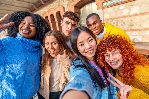 Personal point of view of a group of multiracial young people taking a selfie in the street