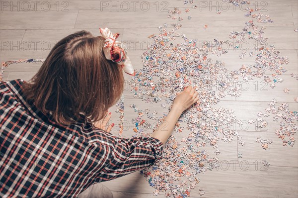 Teenager plays puzzles. The concept of board educational games. Stay at home.