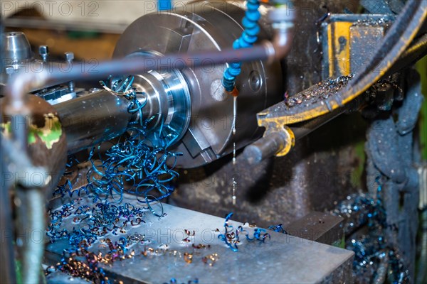 The CNC milling machine cuts metal parts with a milling machine and releasing metal chips. Numerical control workshop