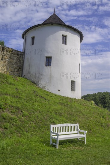 Tower of the fortified village and white bench