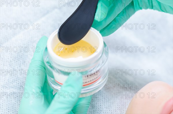 Image of a jar with a yellow mask for skin care. Concept for beauty salons.