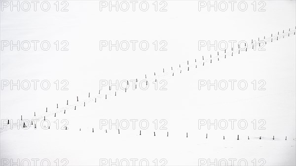 Snow-covered meadow with poles